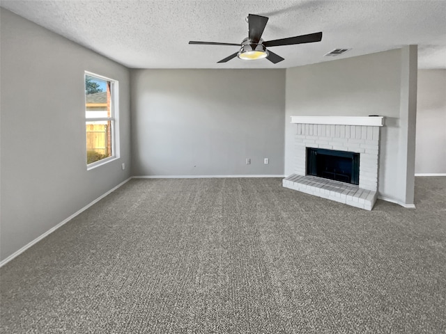 unfurnished living room with a textured ceiling, a brick fireplace, ceiling fan, and carpet flooring