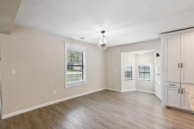 3018 Scorpio Dr, Granbury, TX 76049 - unfurnished room with light wood finished floors, a chandelier, and baseboards