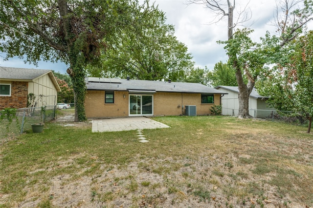 back of property with a lawn, a patio area, and central air condition unit