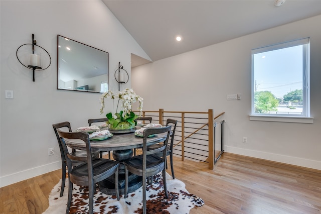 dining room with light hardwood / wood-style floors and vaulted ceiling