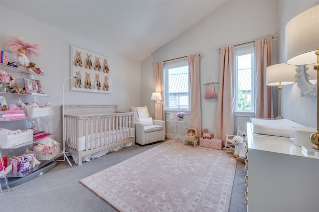 carpeted bedroom featuring a nursery area and vaulted ceiling