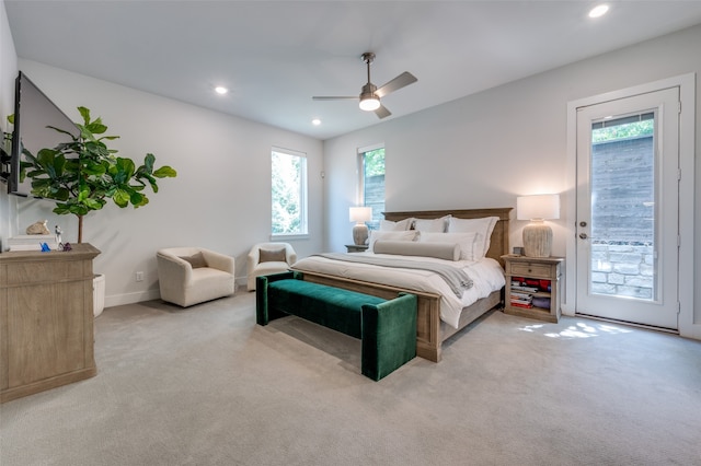 bedroom featuring access to outside, light carpet, multiple windows, and ceiling fan