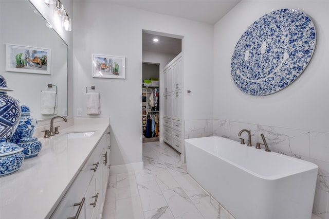 bathroom with tile walls, vanity, and a tub