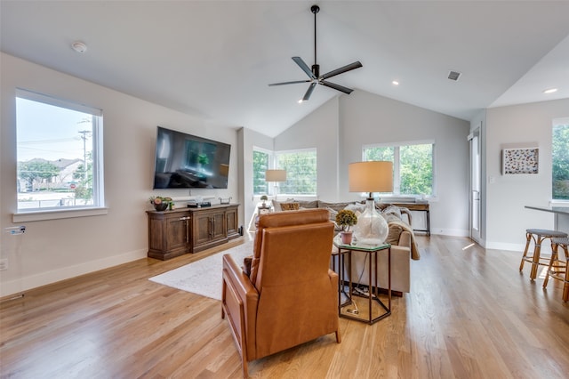 living room with light hardwood / wood-style flooring, a wealth of natural light, vaulted ceiling, and ceiling fan