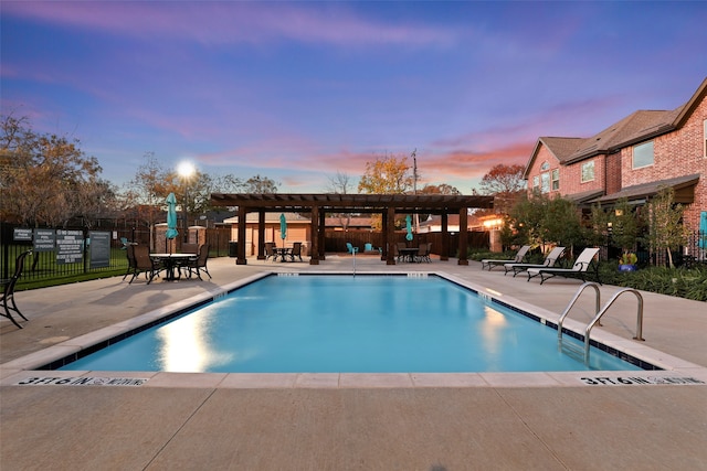 pool at dusk featuring a pergola and a patio area