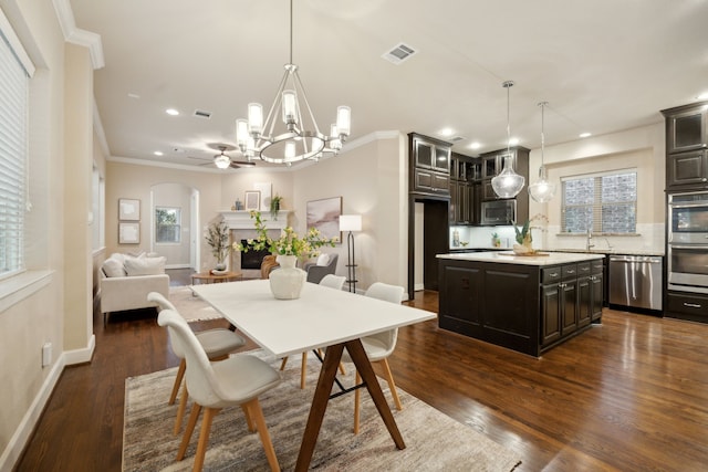 dining room featuring crown molding, an inviting chandelier, sink, and dark hardwood / wood-style floors