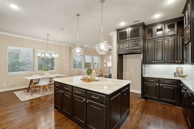 kitchen featuring dark wood-type flooring, backsplash, decorative light fixtures, and light stone countertops