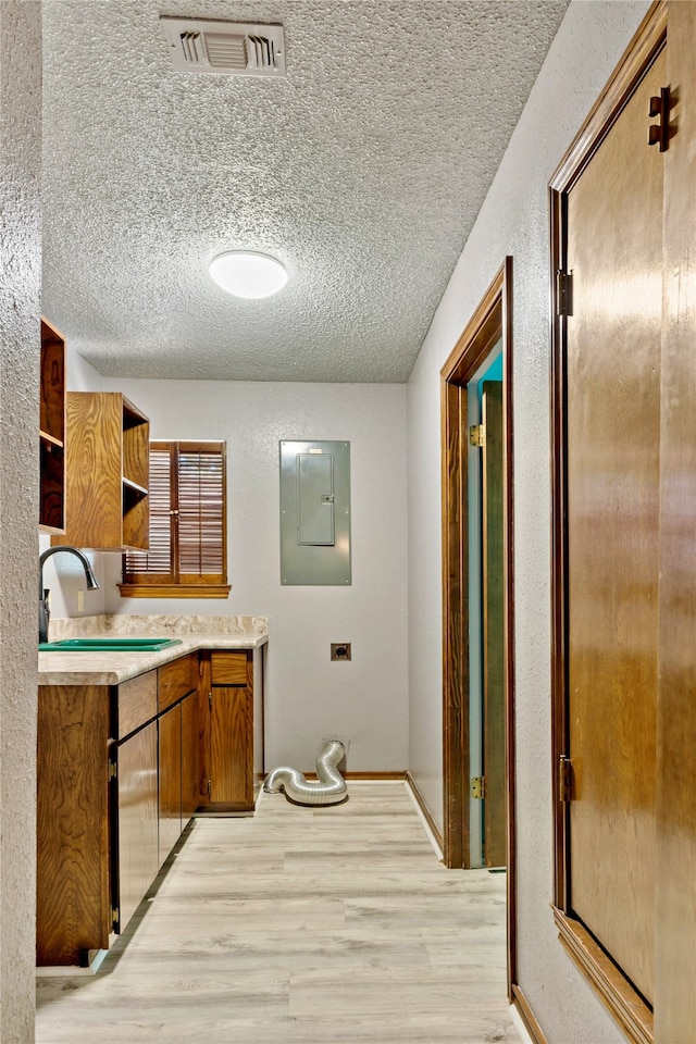 bathroom with vanity, a textured ceiling, hardwood / wood-style floors, and electric panel