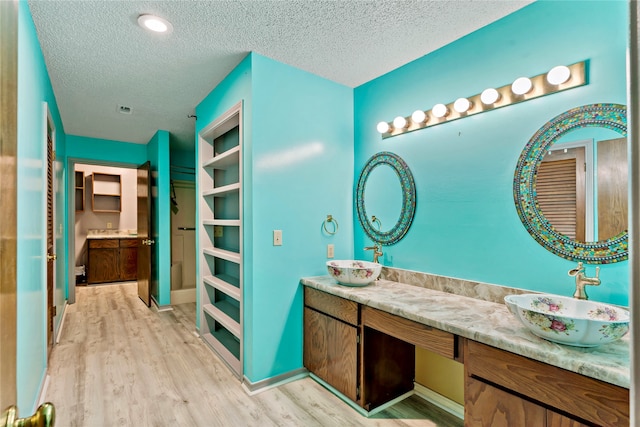 bathroom featuring wood-type flooring, a textured ceiling, and vanity