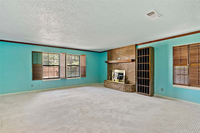 unfurnished living room featuring a fireplace, carpet, crown molding, and a textured ceiling