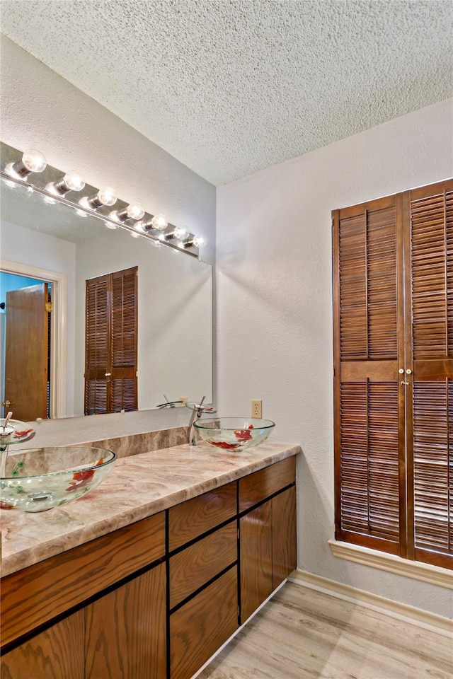 bathroom featuring vanity, a textured ceiling, and hardwood / wood-style floors