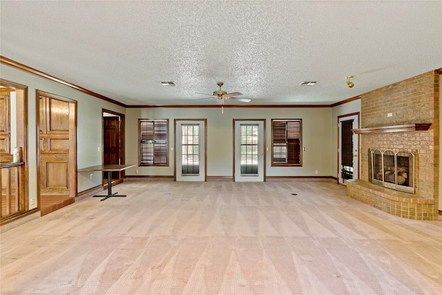 unfurnished living room with a fireplace, crown molding, a textured ceiling, ceiling fan, and light colored carpet