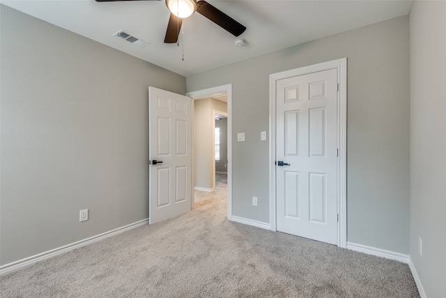 unfurnished bedroom featuring light colored carpet and ceiling fan