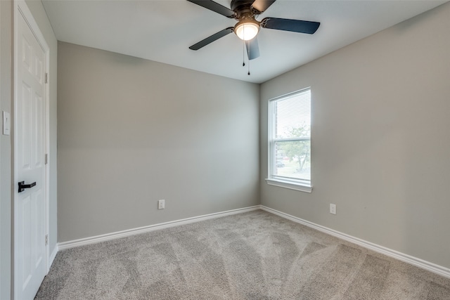 spare room with ceiling fan and light carpet