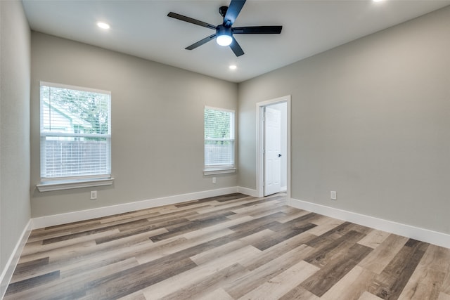 empty room featuring light hardwood / wood-style flooring, ceiling fan, and a healthy amount of sunlight