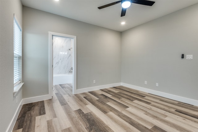 empty room with ceiling fan, plenty of natural light, and light hardwood / wood-style floors