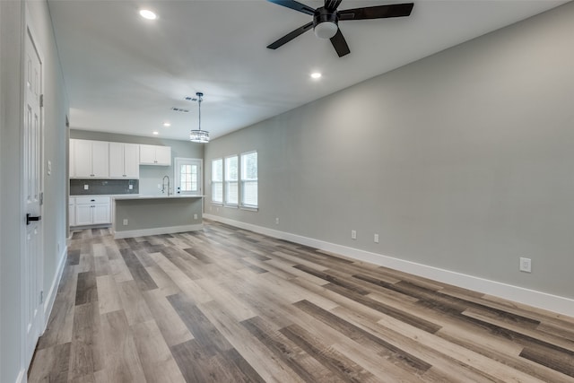 unfurnished living room with light wood-type flooring and ceiling fan