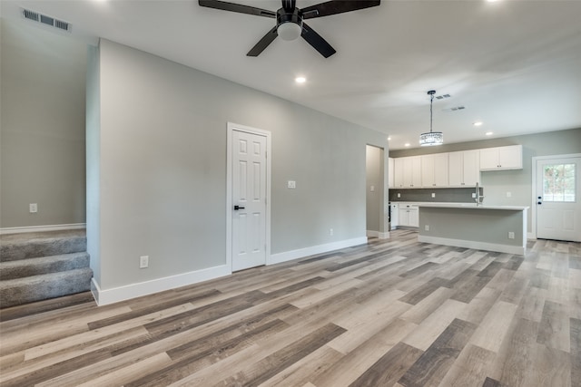 unfurnished living room with ceiling fan and light hardwood / wood-style floors