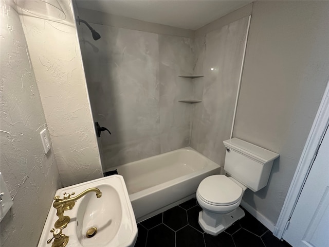 bathroom with tile patterned flooring, toilet, and tiled shower / bath combo