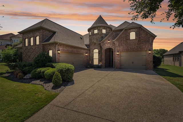 french country style house featuring a lawn and a garage