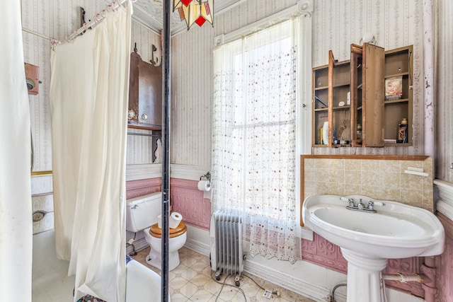 bathroom with shower / tub combo, toilet, radiator heating unit, and tile patterned flooring