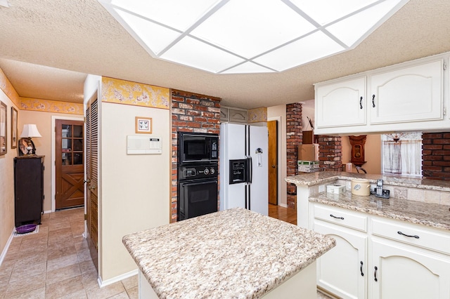 kitchen featuring black appliances, a textured ceiling, a kitchen island, light stone counters, and white cabinetry