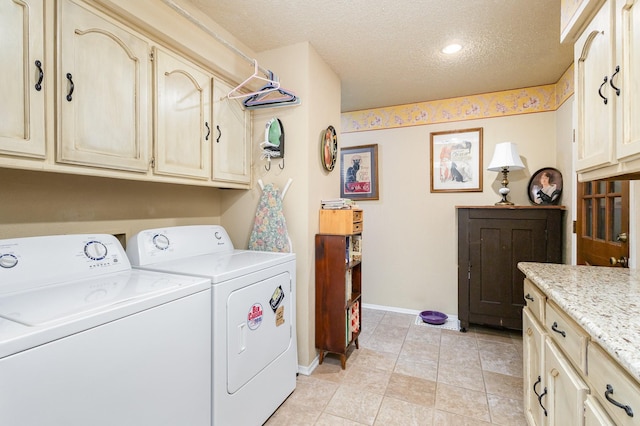 laundry room with cabinets, a textured ceiling, washing machine and dryer, and light tile patterned flooring