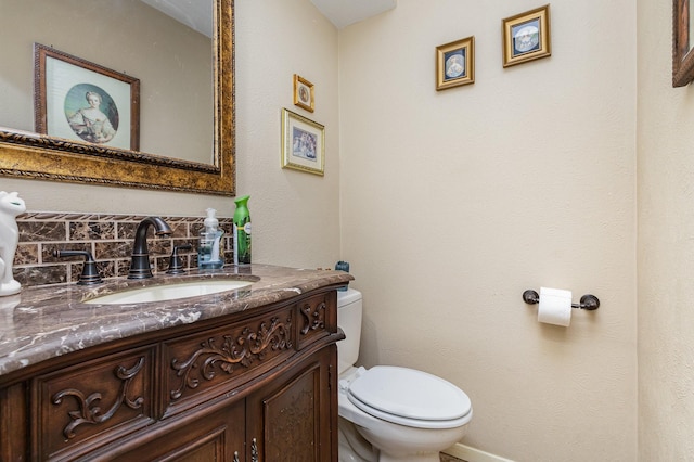 bathroom featuring vanity, tasteful backsplash, and toilet