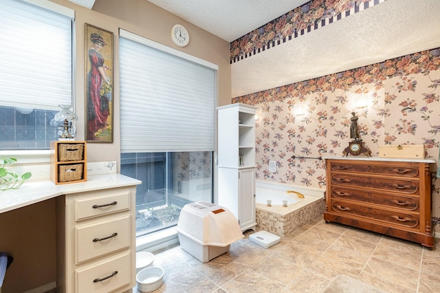 bathroom with a textured ceiling and a bath