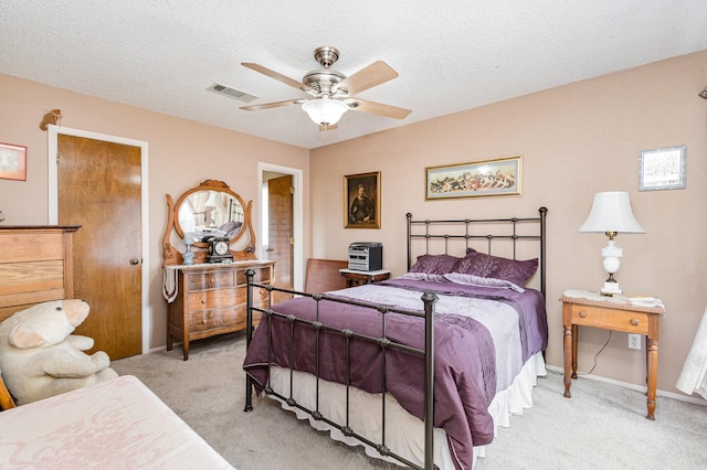 bedroom featuring a textured ceiling, ceiling fan, and light carpet