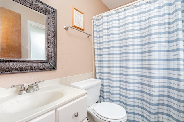 bathroom with vanity, curtained shower, and toilet