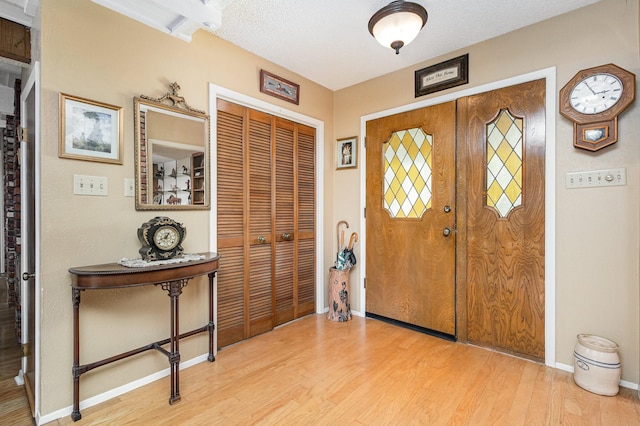 entrance foyer with a textured ceiling and light hardwood / wood-style flooring