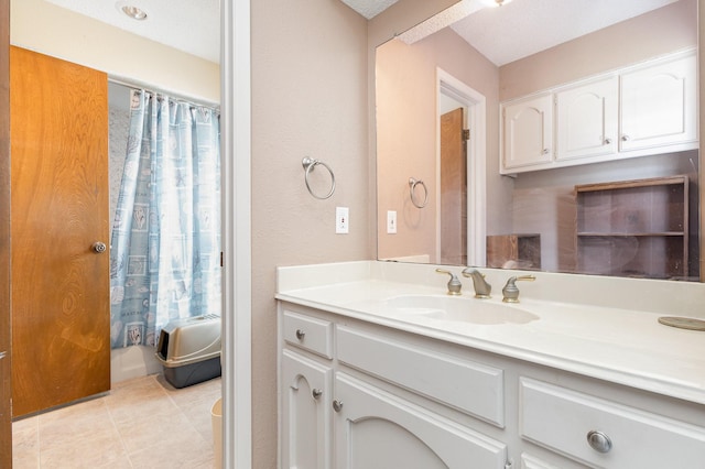 bathroom featuring tile patterned floors, vanity, and a textured ceiling