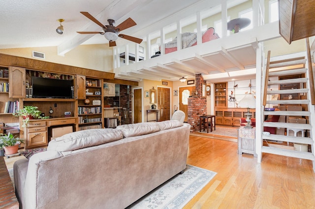 living room featuring ceiling fan, beam ceiling, light wood-type flooring, and high vaulted ceiling