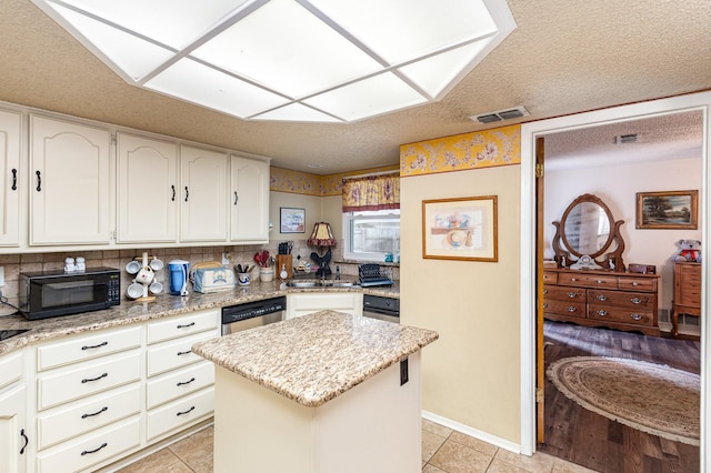 kitchen with light stone countertops, tasteful backsplash, dishwasher, light hardwood / wood-style floors, and a kitchen island