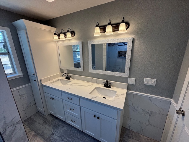 bathroom with tile walls, a textured ceiling, and vanity