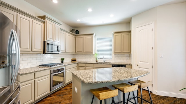 kitchen with dark hardwood / wood-style floors, backsplash, a center island, stainless steel appliances, and sink