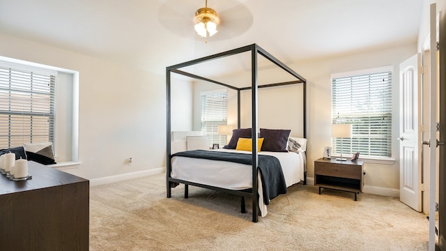 bedroom with ceiling fan and light carpet