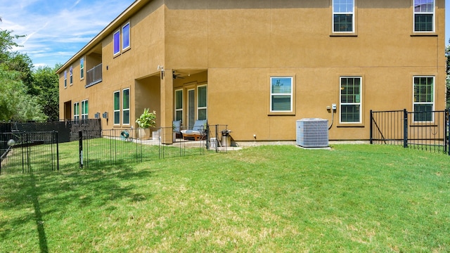 rear view of house featuring cooling unit, a yard, and a patio