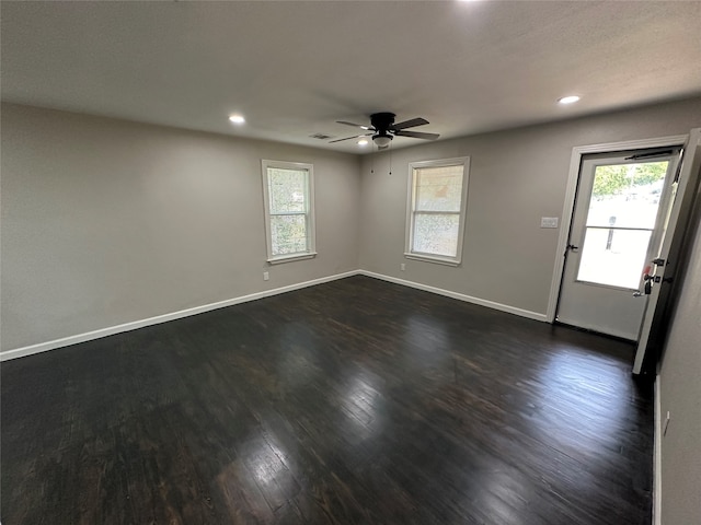 empty room with dark wood-type flooring and ceiling fan