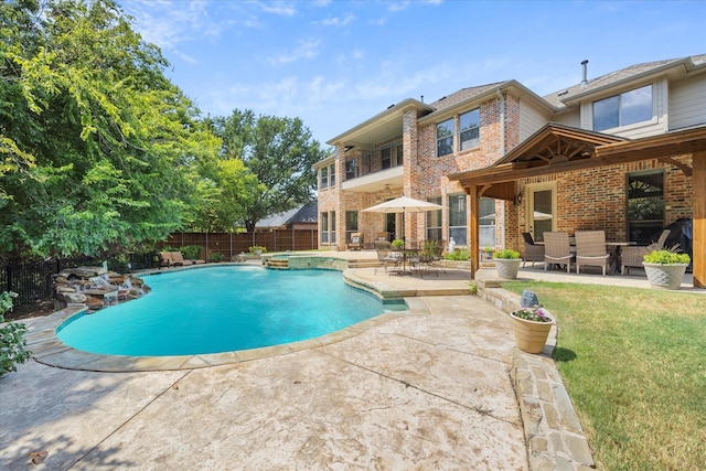 view of pool with an in ground hot tub, a yard, and a patio