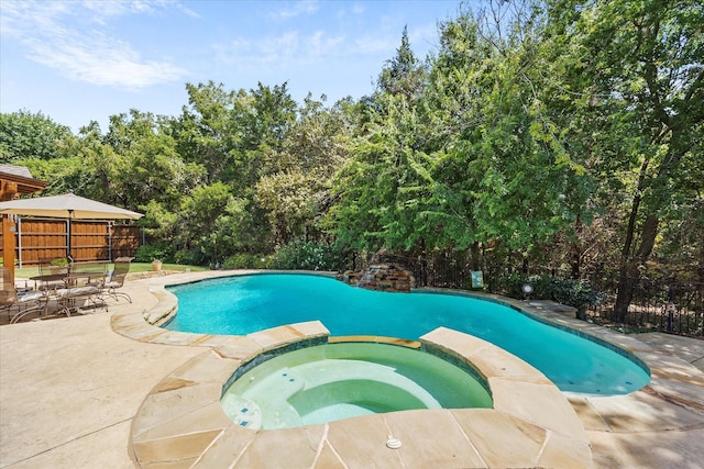 view of swimming pool featuring a patio area and an in ground hot tub