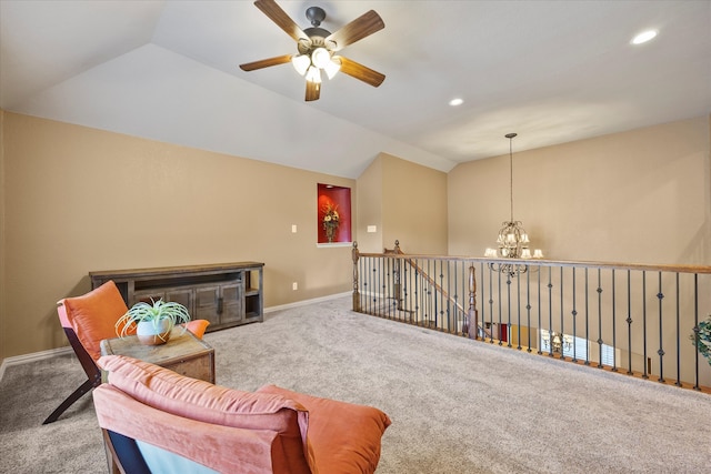 sitting room with a fireplace, ceiling fan with notable chandelier, light colored carpet, and vaulted ceiling