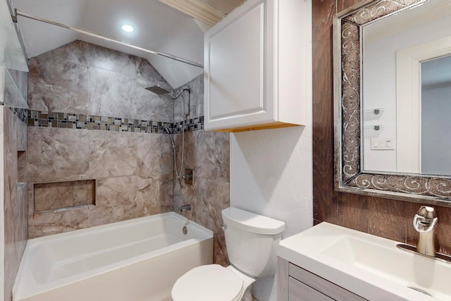 full bathroom featuring lofted ceiling, vanity, tiled shower / bath, and toilet