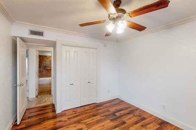 unfurnished bedroom featuring a closet, ceiling fan, dark hardwood / wood-style flooring, and ornamental molding