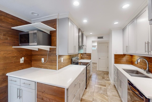 kitchen featuring white cabinets, stainless steel appliances, sink, and wall chimney range hood