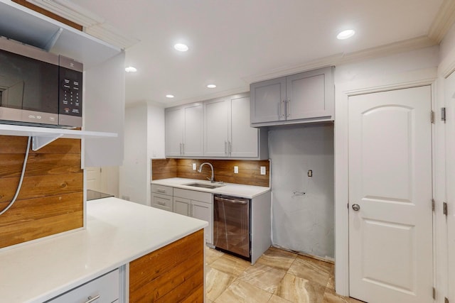 kitchen featuring gray cabinets, crown molding, stainless steel appliances, sink, and decorative backsplash