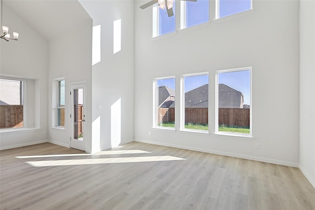 unfurnished living room featuring light wood-style flooring, baseboards, and a wealth of natural light