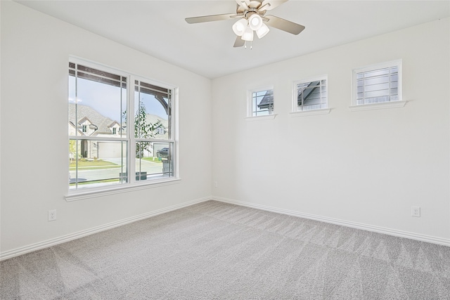 spare room with carpet, baseboards, and a ceiling fan