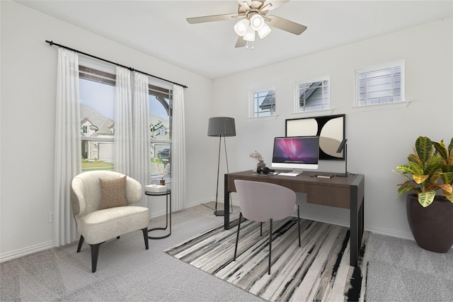 office space featuring baseboards, a ceiling fan, and light colored carpet